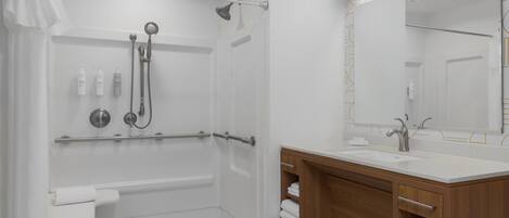 A modern bathroom with a shower, a sink, and a vanity.