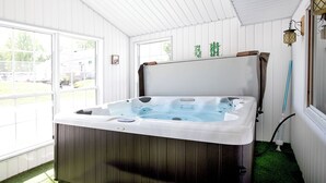 Un jacuzzi en una habitación con paredes blancas y ventanas amplias.