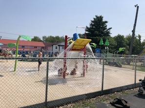 Children can play and splash in the playground's water feature with multiple slides and water jets.