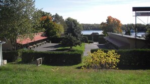 A hotel with a parking lot, a view of a lake, and a sign indicating a motel.