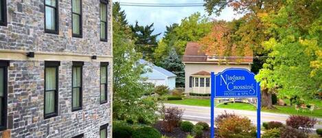 A hotel sign with a stone building in the background.