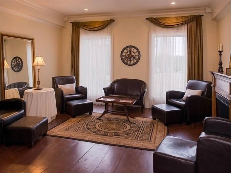 A well-furnished living room with leather sofas, a coffee table, and a patterned rug.