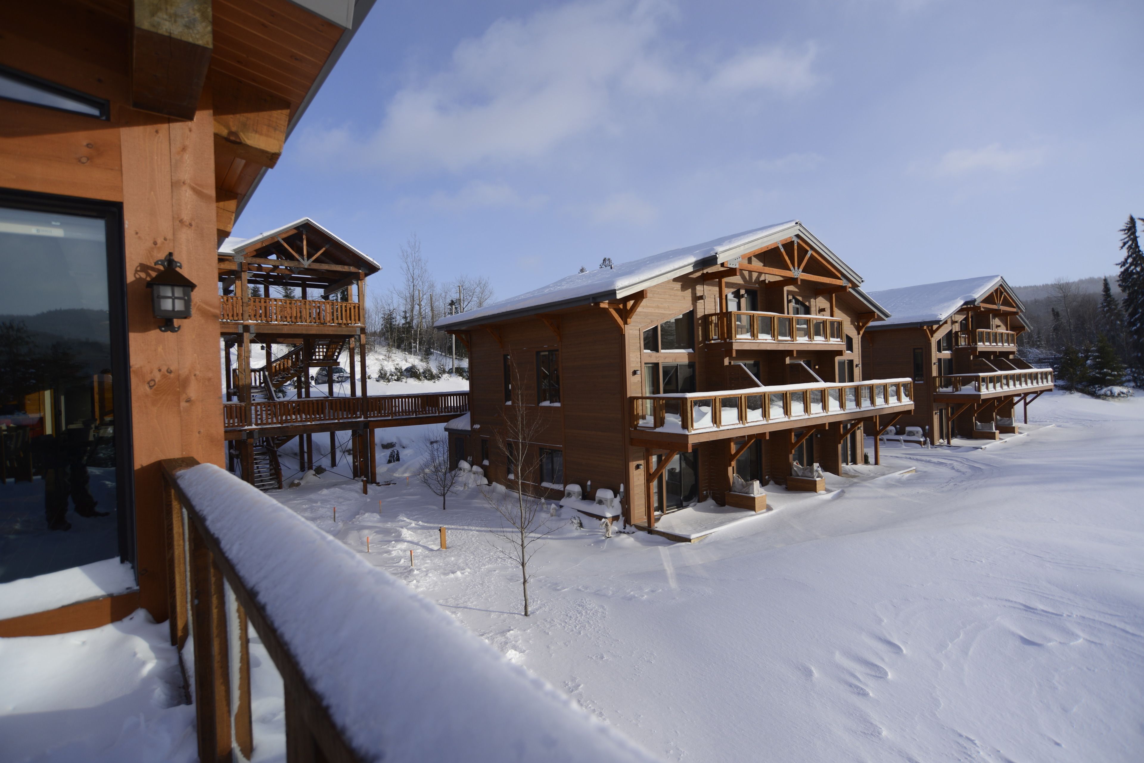 A wooden lodge with multiple balconies and a snowy landscape.