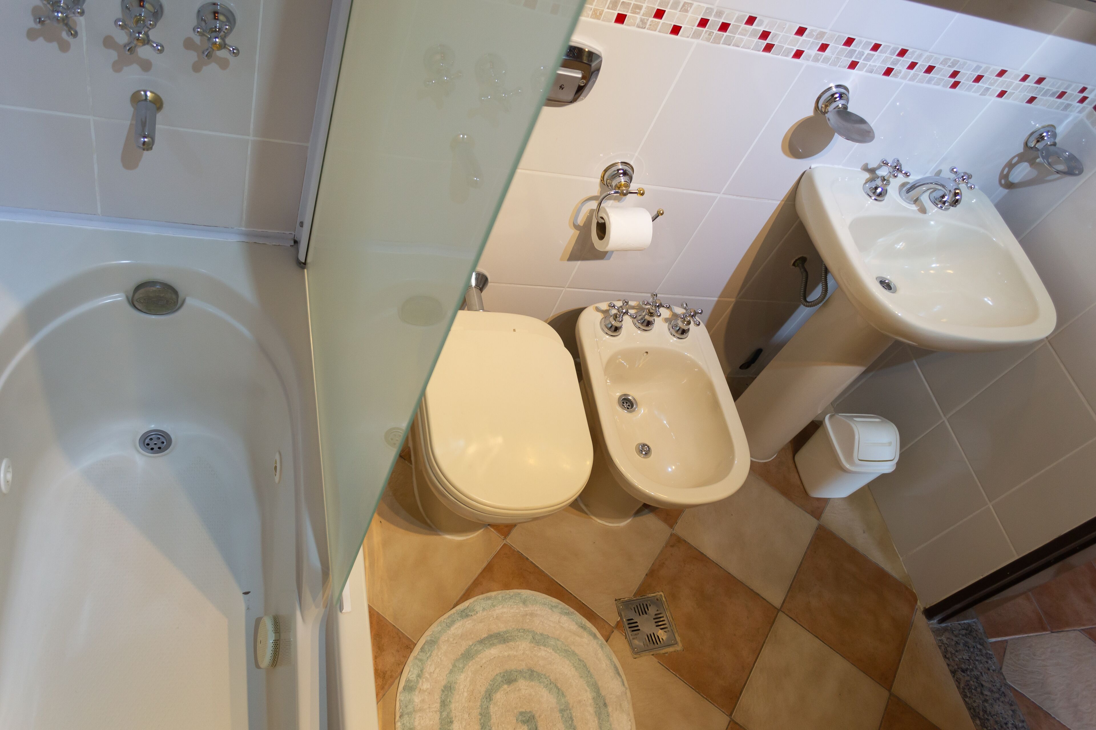 A bathroom with a bathtub, toilet, bidet, and sink.