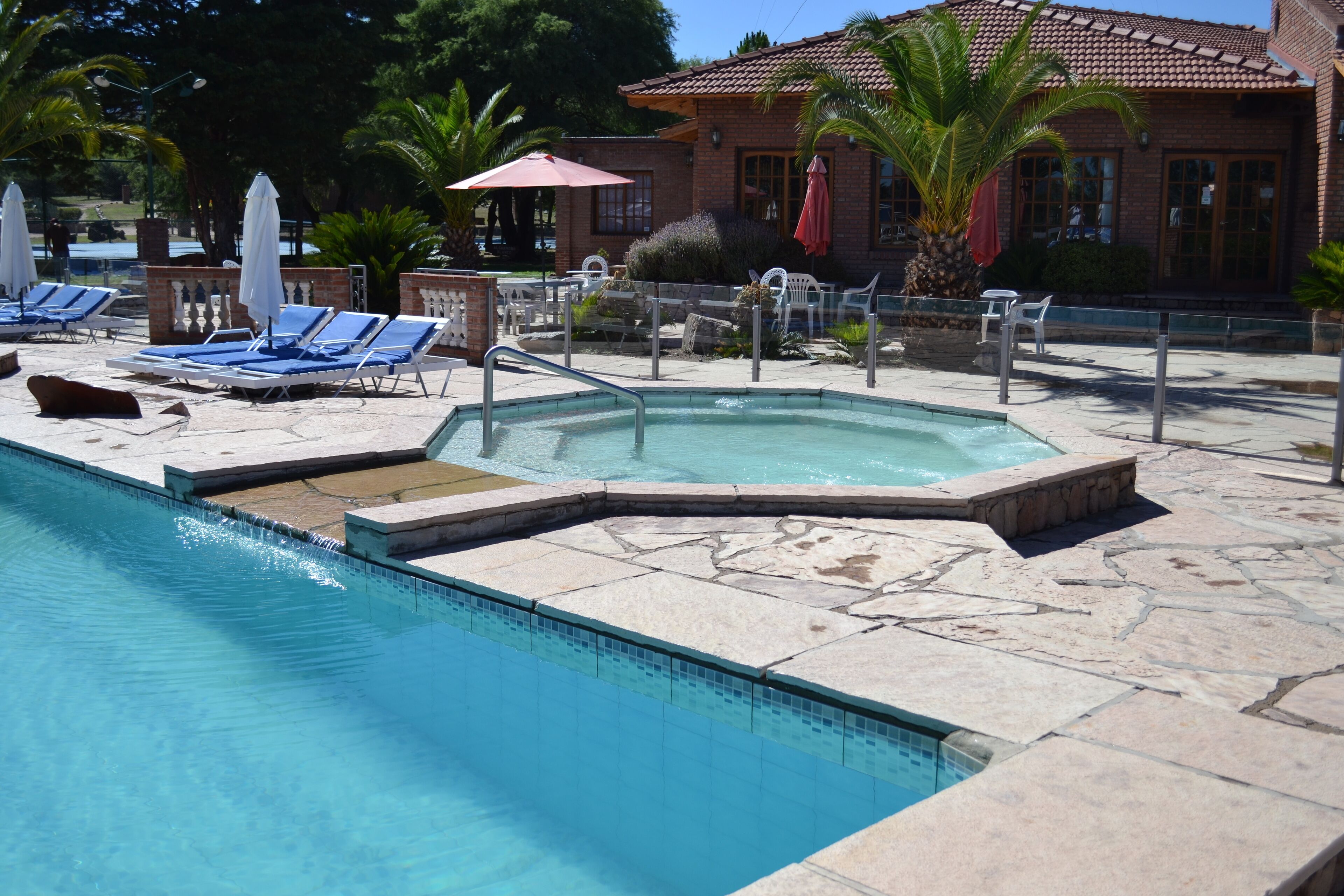 Un área de piscina con sillones de descanso y un jacuzzi.