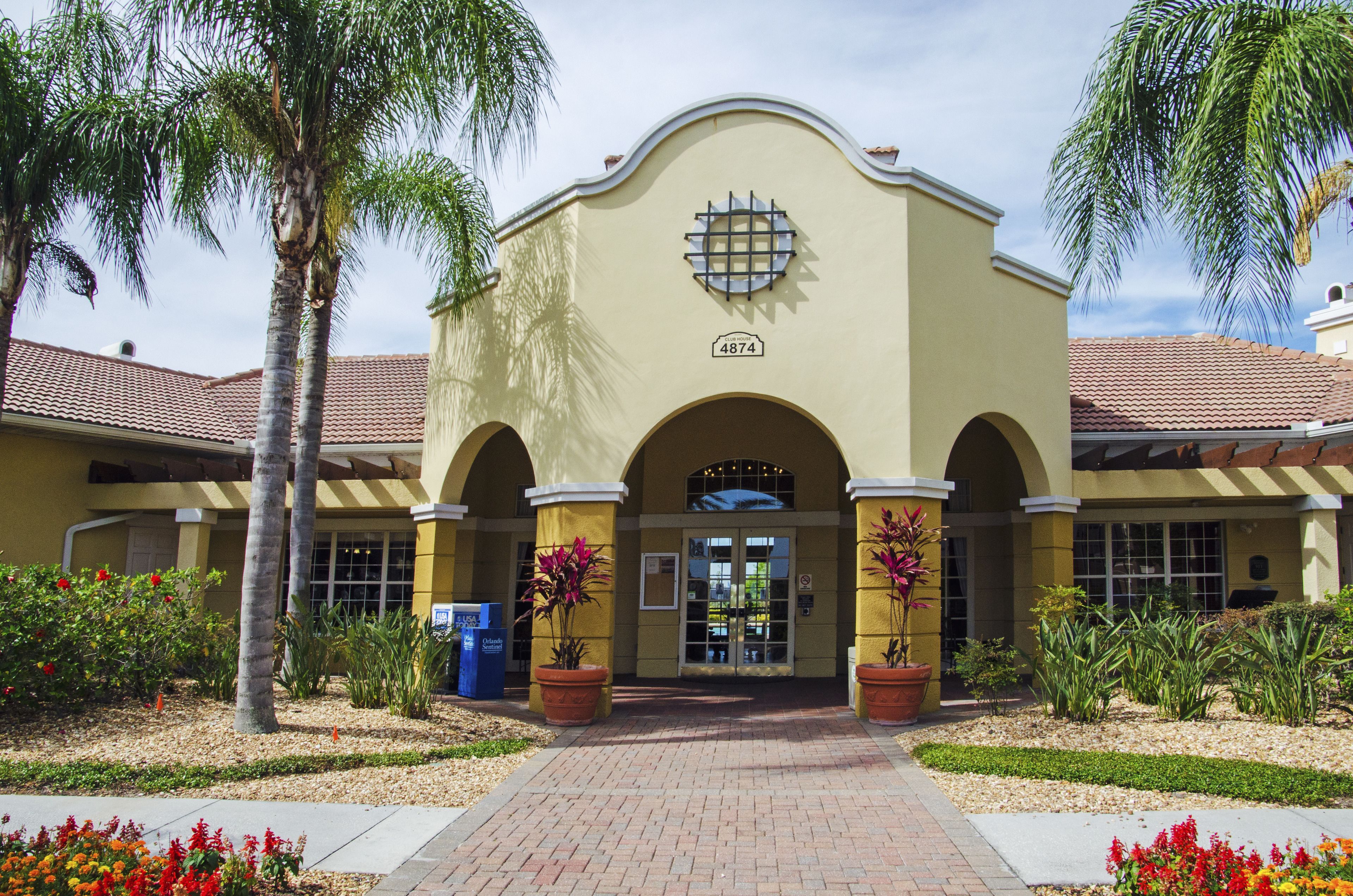 A building with a yellow facade, arched entrance, and a number "4874" sign.