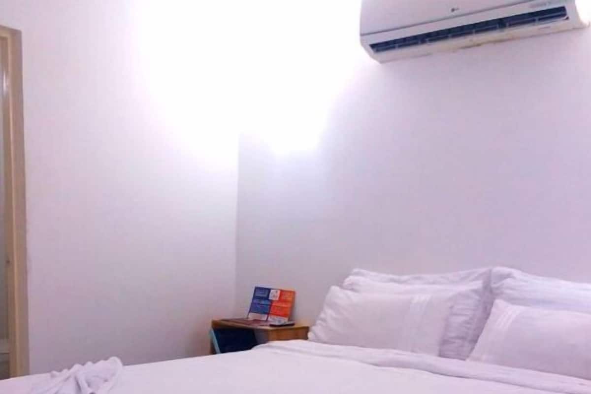 Ein ordentlich bezogenes Bett mit weißen Leinen in einem Hotelzimmer.