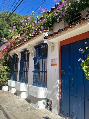 A building with blue doors and windows, a white facade, and a sign that reads 'Zana.'