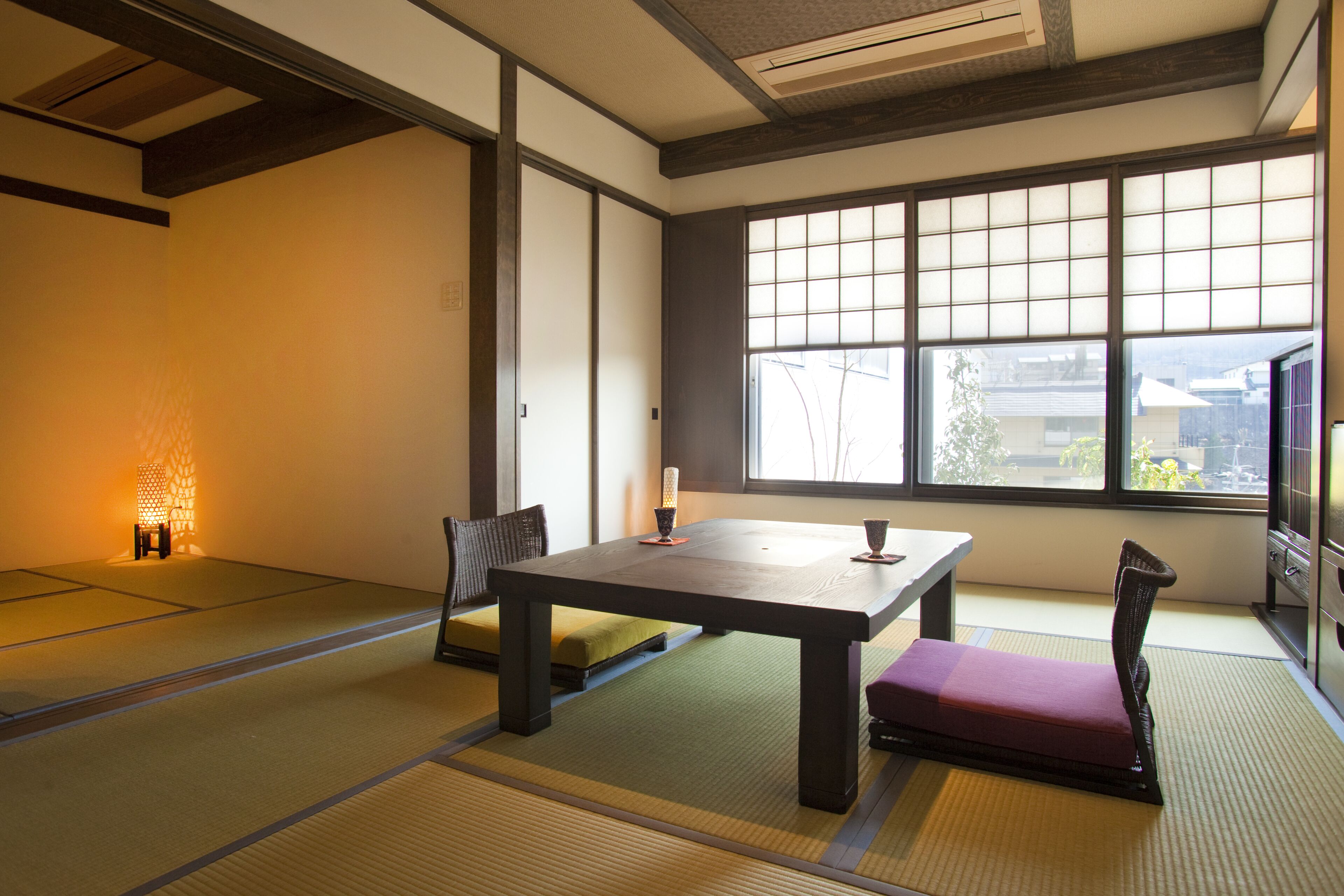 A traditional Japanese room with tatami flooring, a low table, and cushions.