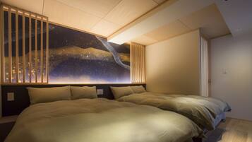 A bedroom with two beds, a large wall mural, and a slanted ceiling.