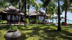 A resort with thatched-roof structures, palm trees, and a view of the sea. - Mali Resort Pattaya Beach Koh lipe (Koh Lipe)