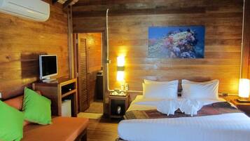 Una camera in legno con un letto, una TV, una scrivania e un quadro appeso al muro.