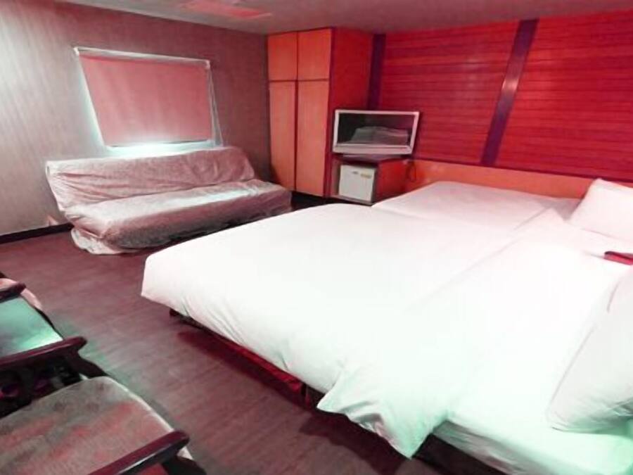 Une chambre d’hôtel avec un lit, une télévision, un bureau et une chaise.
