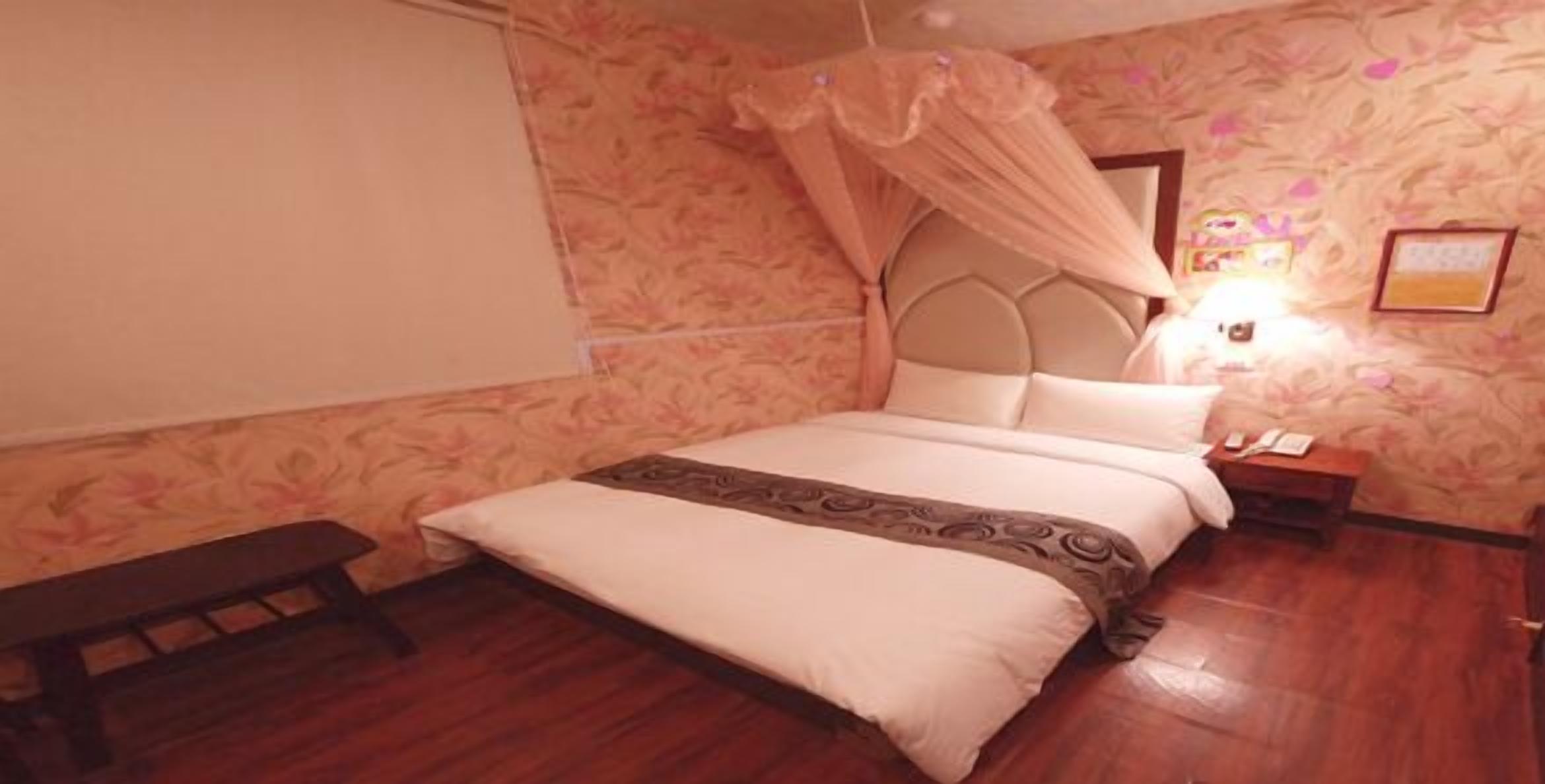 A bedroom with a bed, bedside table, and a bench.