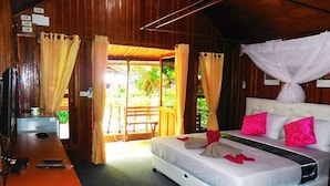 Un dormitorio con cama, cortinas, un escritorio y vistas al exterior.