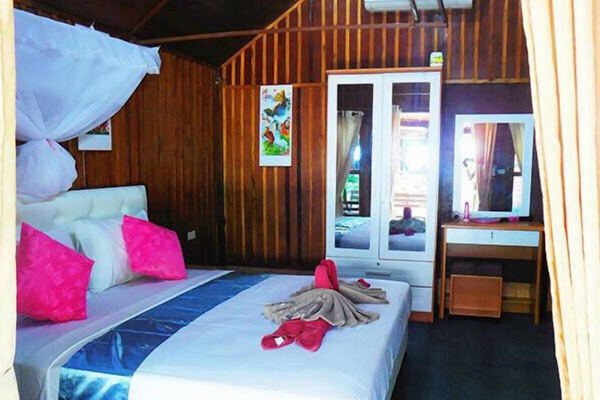 Una habitación con cama, escritorio y ventana.
