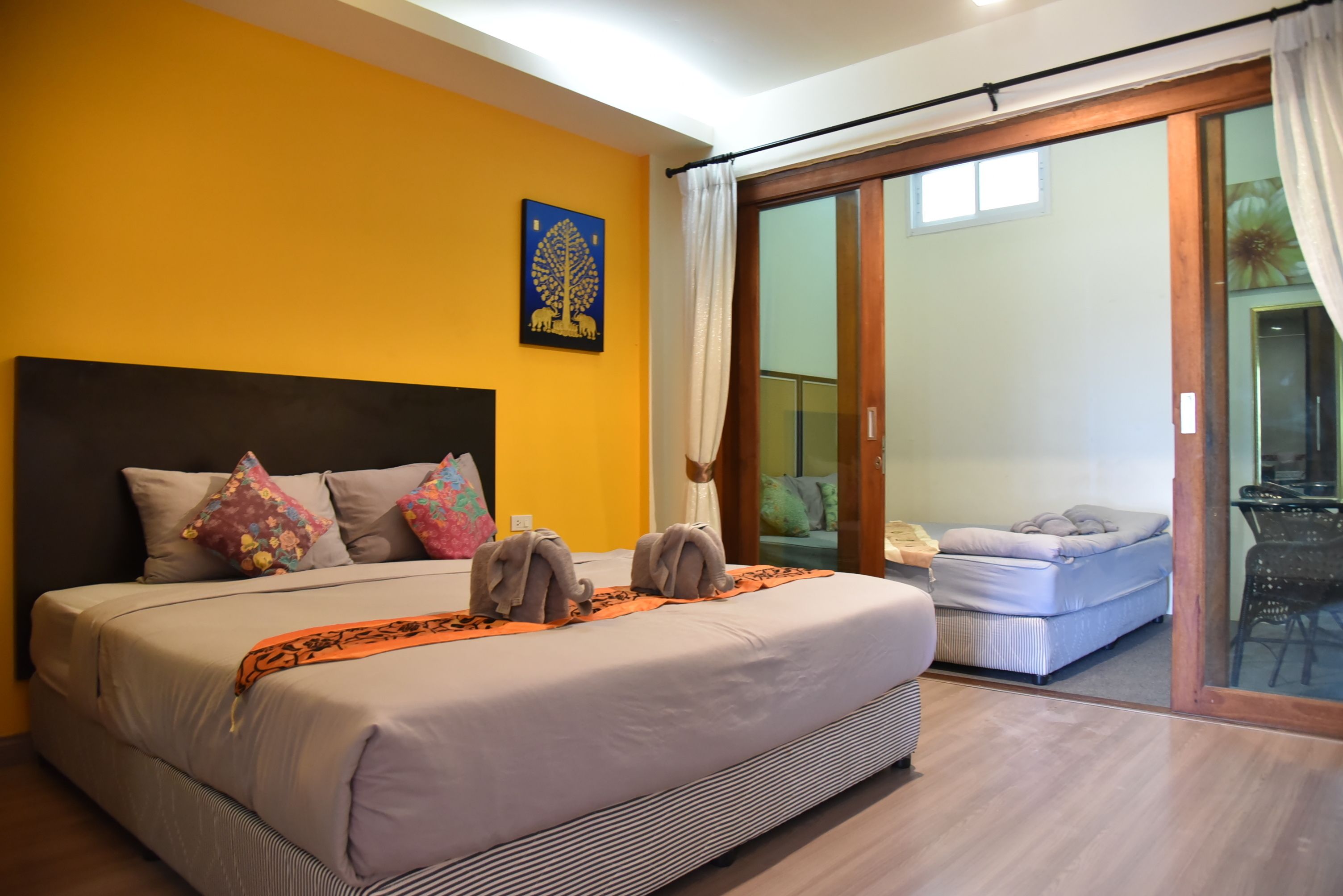 A bedroom with a large bed, a headboard, and a sliding glass door leading to a balcony.