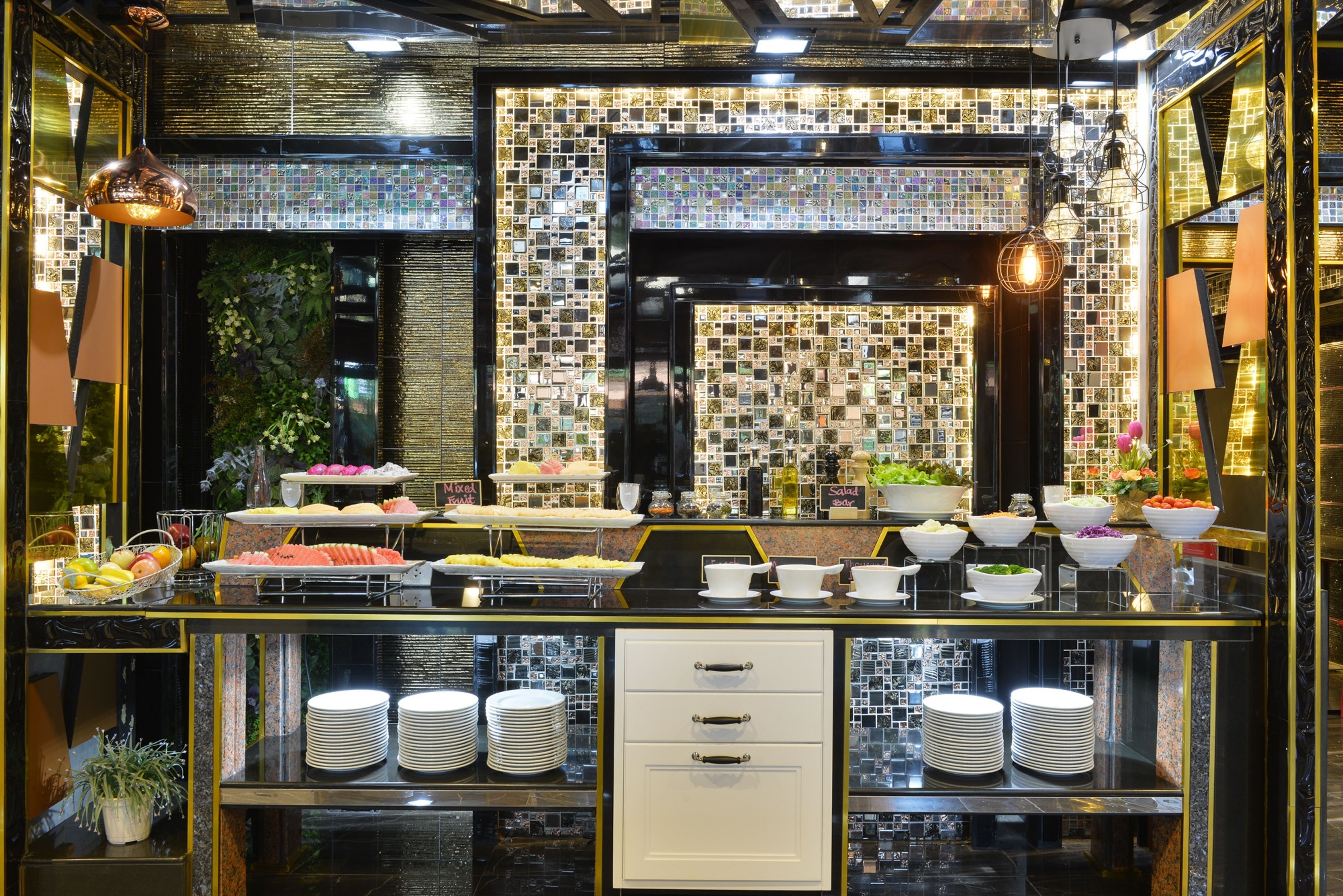 A buffet setup with various food items and a tiled backsplash.
