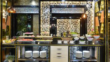 A buffet setup with various food items and a tiled backsplash.