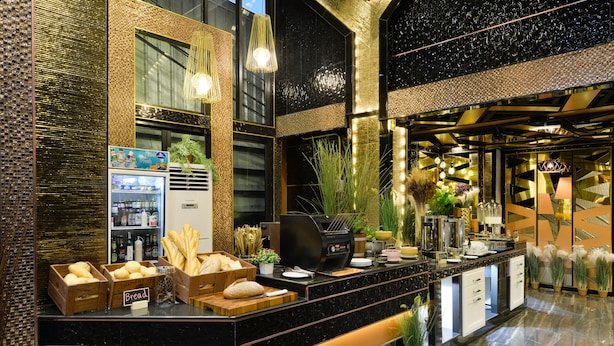 A modern hotel lobby with a marble reception desk, a coffee machine, and a refrigerator stocked with beverages. - Media Hotel & Residence (Bangkok)