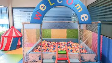 Explore a vibrant play area with a ball pit, slide, and netted play zone, all safely enclosed.