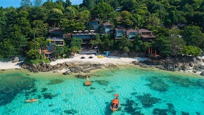 An aerial view of a coastal resort with multiple buildings, clear turquoise waters, and a sandy beach. - The Cliff Lipe (Koh Lipe)
