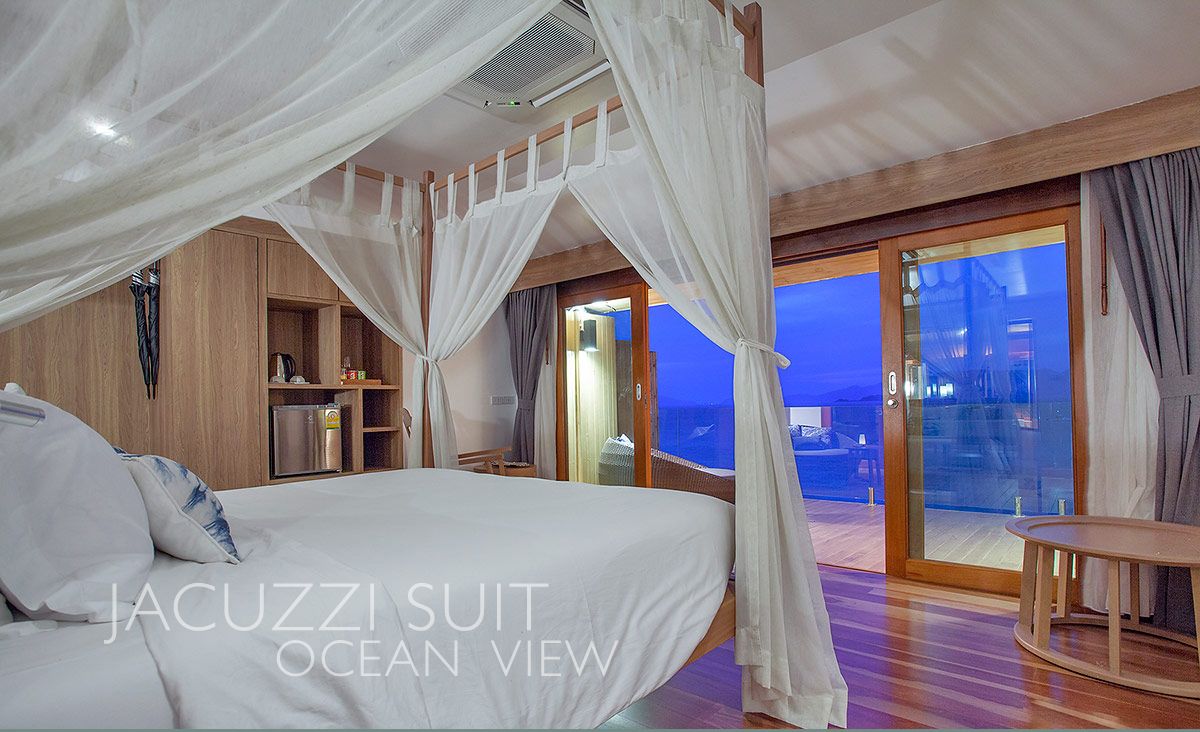 Ein Schlafzimmer mit Himmelsbett, Holzmöbeln und Meerblick.