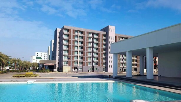 A modern hotel with a swimming pool, multiple floors, and a covered outdoor area. - TM Land Hotel (Bang Pa-in)