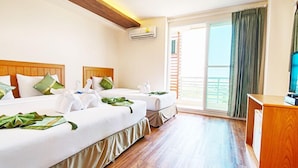 A hotel room with two beds, a wooden ceiling, an air conditioning unit, a TV, and a balcony with curtains. - TM Land Hotel (Bang Pa-in)
