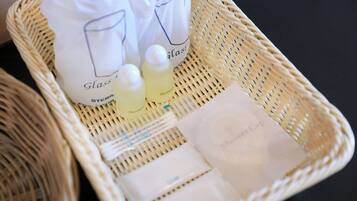 A wicker basket containing a shower cap, a bottle of shampoo, and a bag labeled 'Glass Steril'.