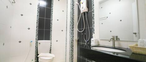 A bathroom with a toilet, a sink, and a shower.