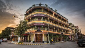 Un hotel de varios pisos con balcones y un letrero que dice "SENG HOUT HOTEL".