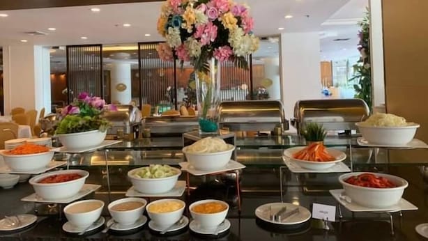 Montaje de bufé con diversas opciones de comida y un centro de mesa floral.