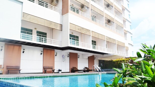 Ein modernes Hotel mit Schwimmbad, mehreren Balkonen und Außenbereichen zum Sitzen.