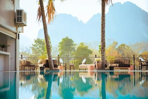 Ein Poolbereich mit Liegestühlen und Bergblick.