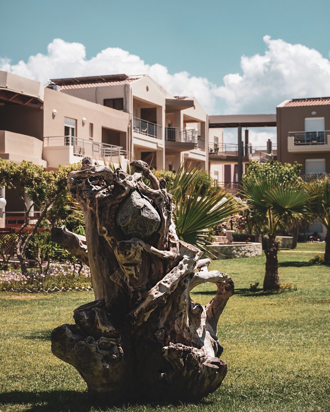 A sculpture in a landscaped area with a building in the background.