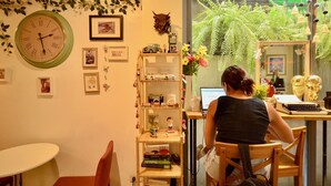 A room with a desk, chair, bookshelf, and a large clock on the wall. - Good Day Hostel (Bangkok)