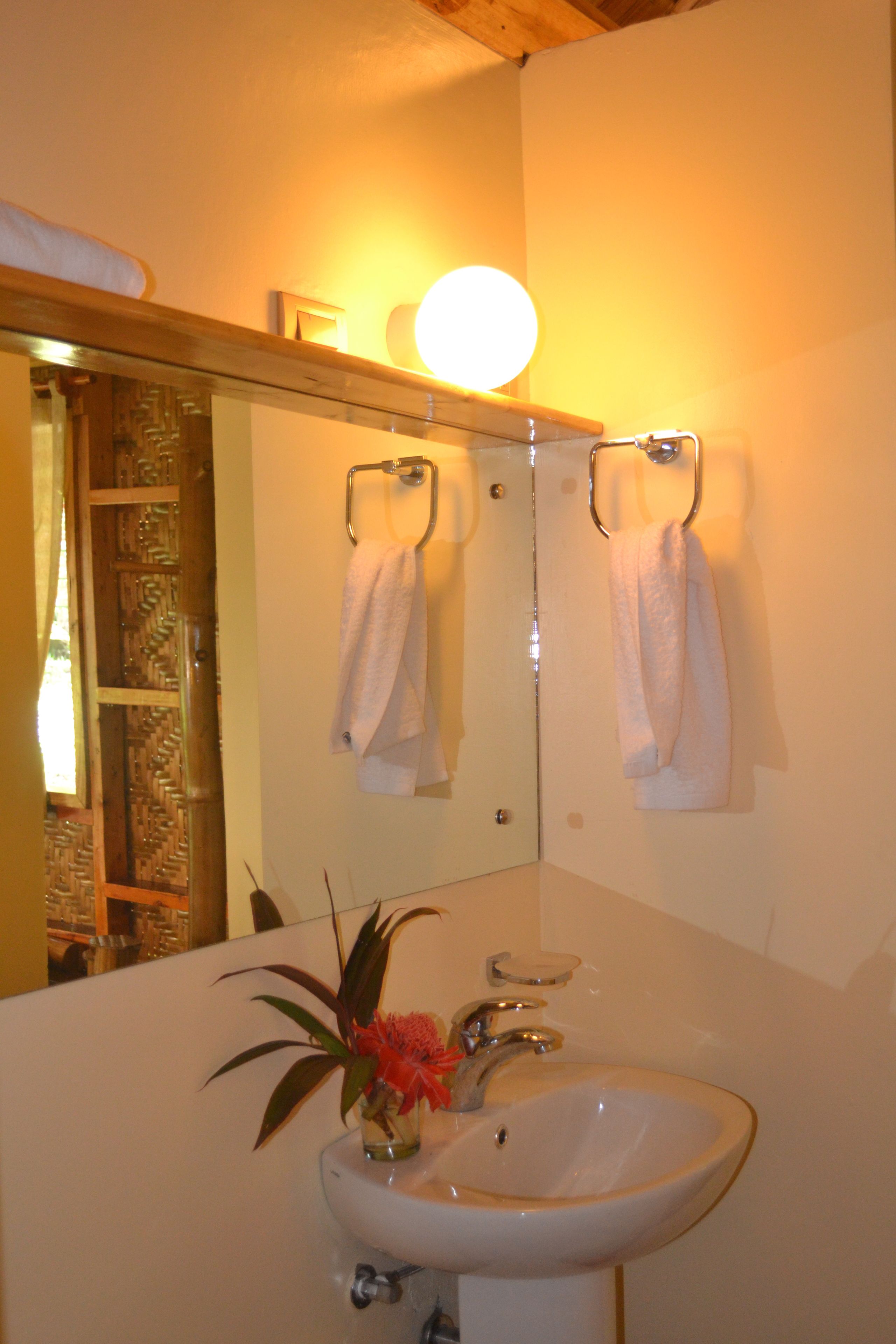 A bathroom with a sink, mirror, and towel rack.