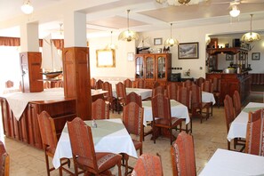 Enjoy a classic dining experience in this beautifully appointed room with a high ceiling, ornate chandeliers, and traditional furnishings.