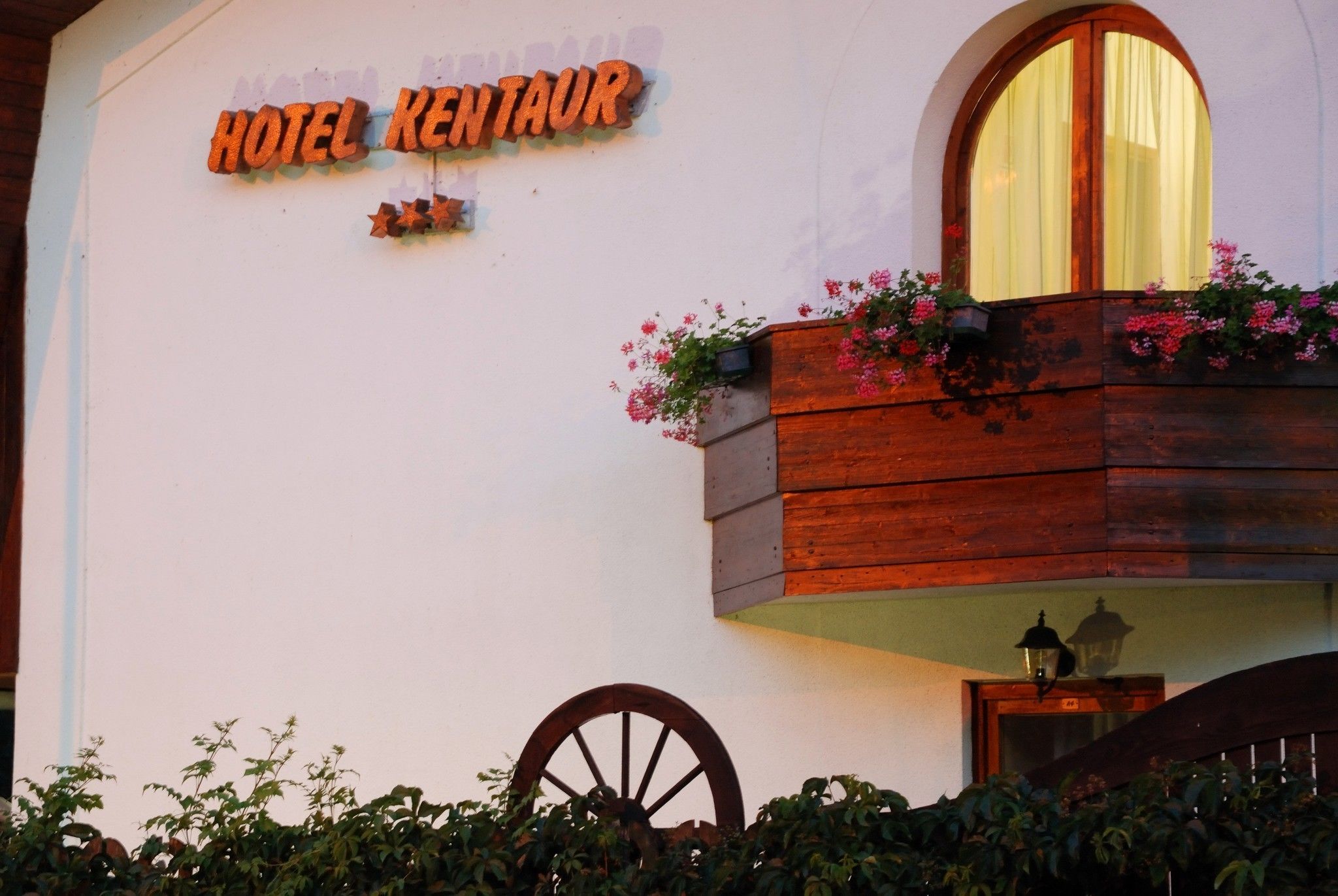 A building with a sign reading "HOTEL KENTAUUR" and a wooden balcony with flowers.