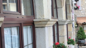 Una hilera de edificios de piedra con ventanas de arco y macetas con flores en la planta baja.