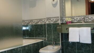 Ein Badezimmer mit Toilette, Bidet, Waschbecken und Spiegel.