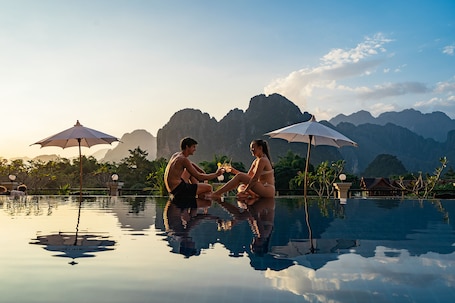 Una piscina al aire libre, sillones reclinables de piscina