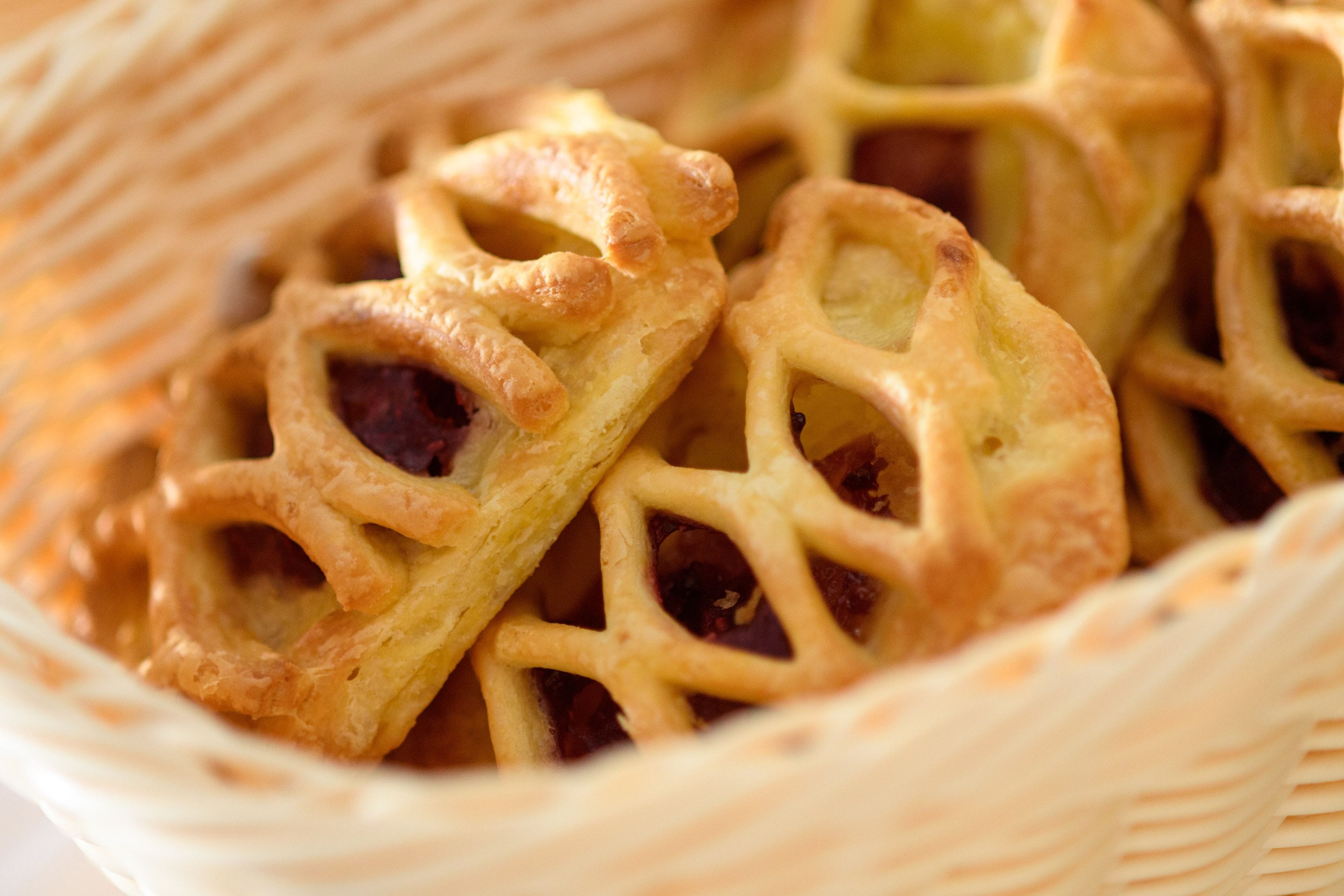 A basket containing several fruit tarts with a lattice crust.