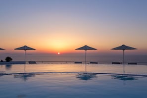 Alberca al aire libre, alberca infinita y sombrillas en la alberca