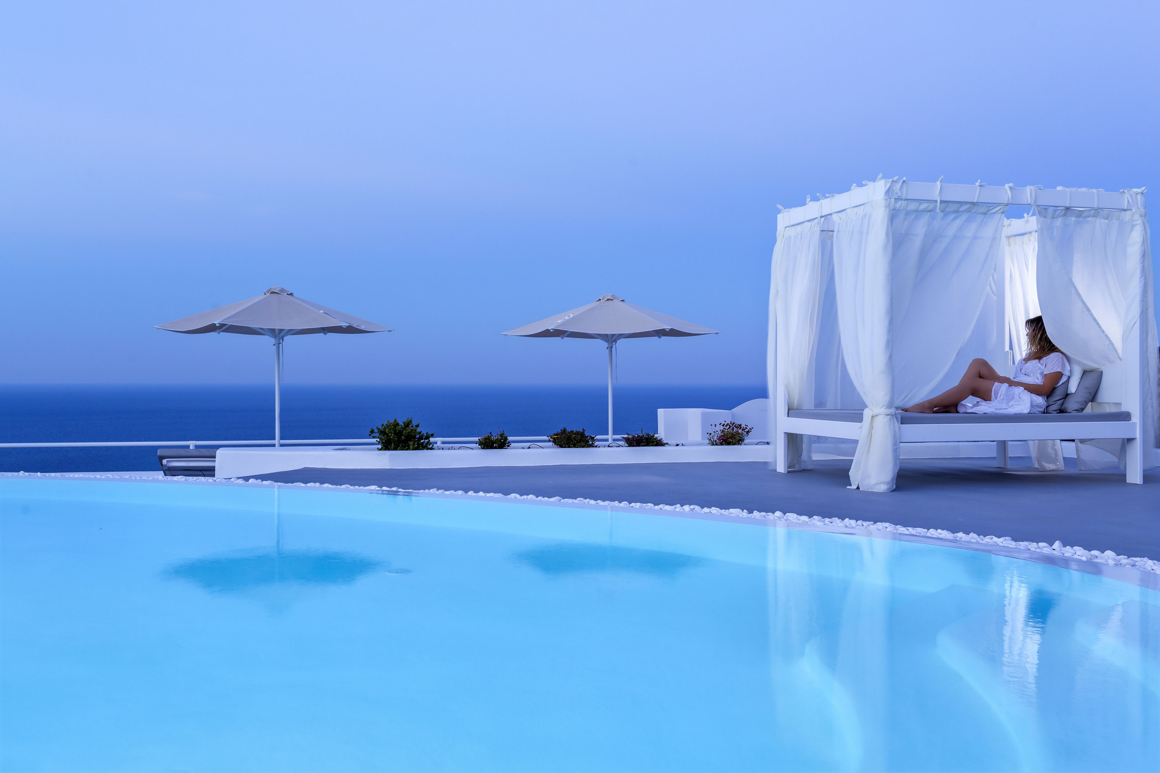 outdoor pool, an infinity pool, pool umbrellas, pool loungers