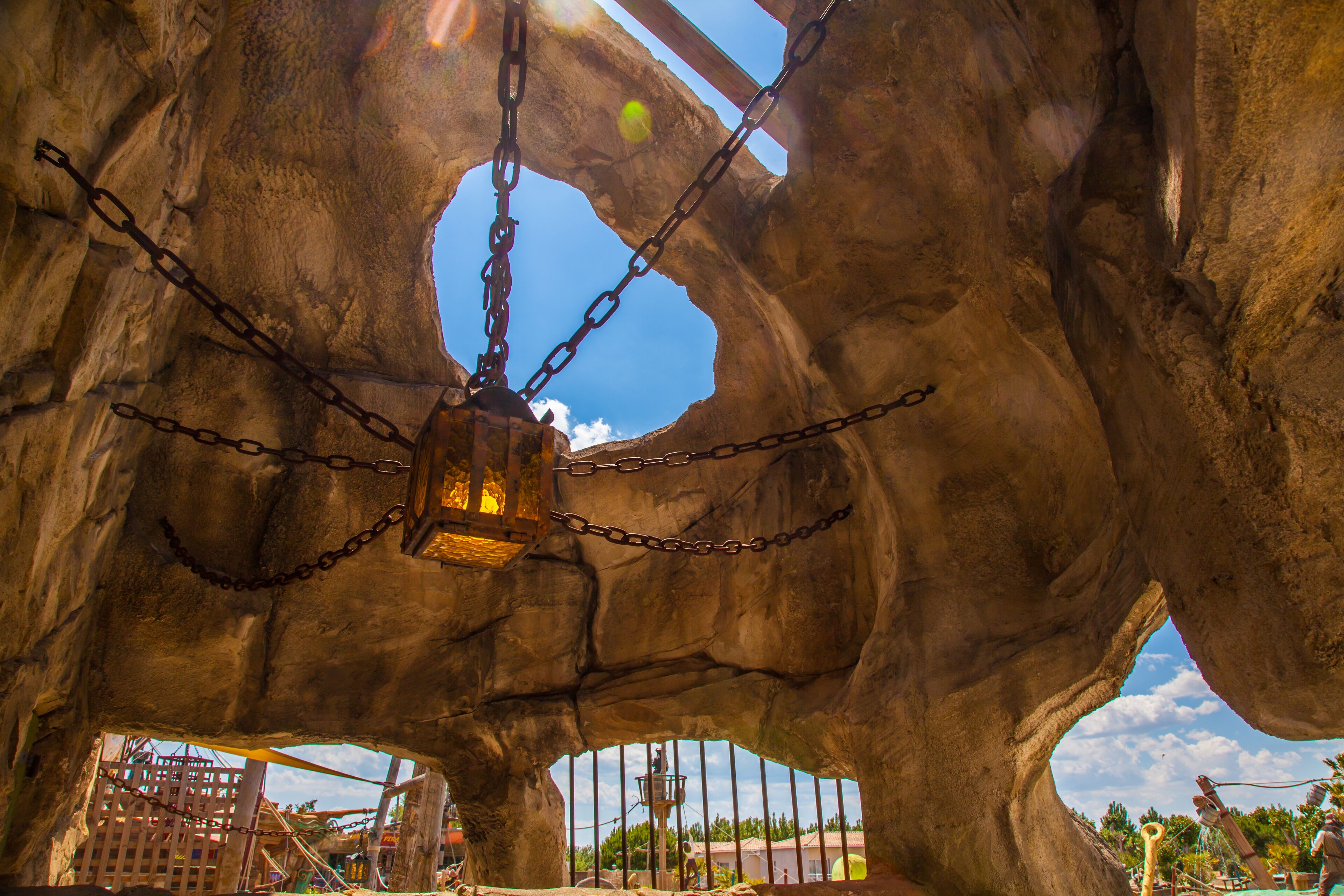 A large rock structure with chains and a hanging lantern.