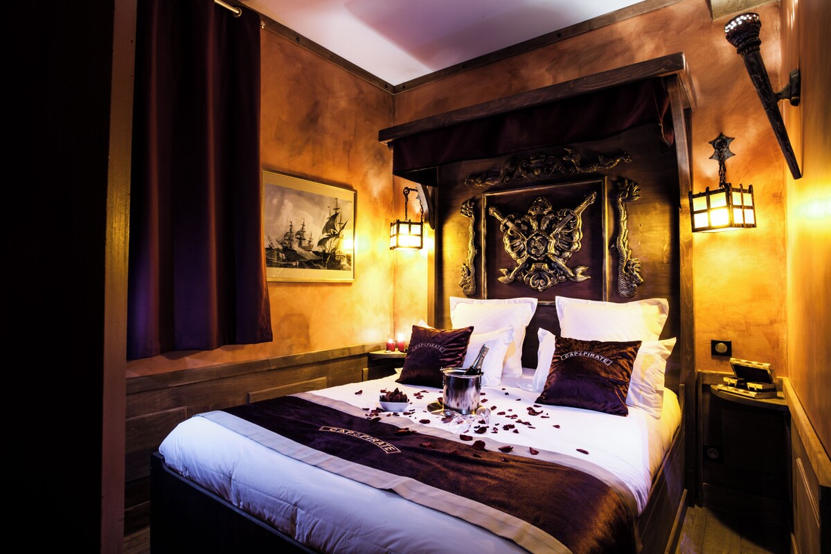 A bed with a decorative headboard, a nightstand with a lamp, and a framed picture on the wall.