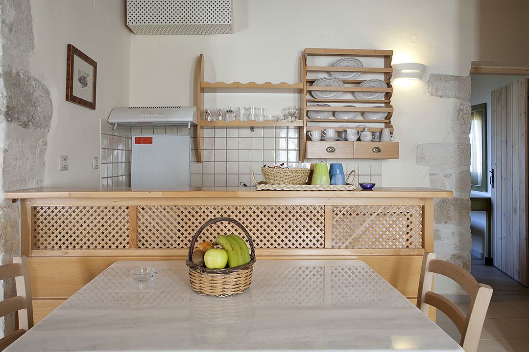 Une cuisine avec un plan de travail en bois, un pare-feu en carrelage et un panier de fruits sur la table.