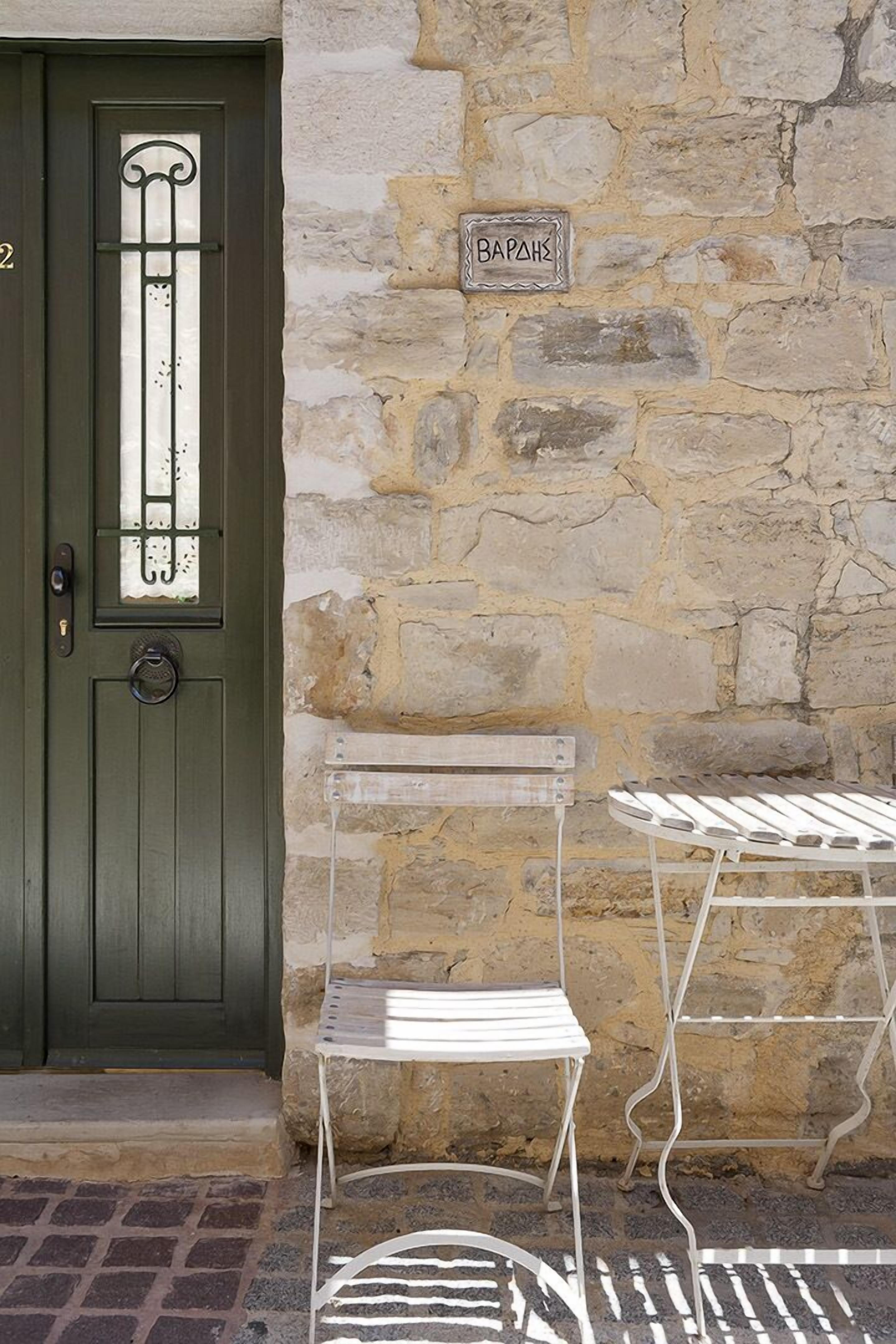 A stone wall with a metal sign reading "BAPAHZ" and a green door with a metal gate.
